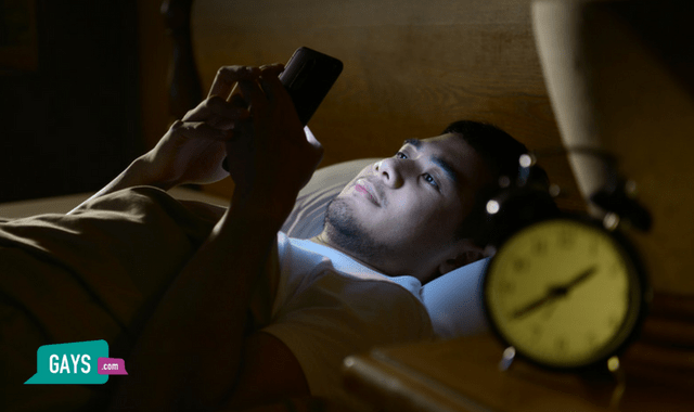 Man in bed at night obsessed with his phone